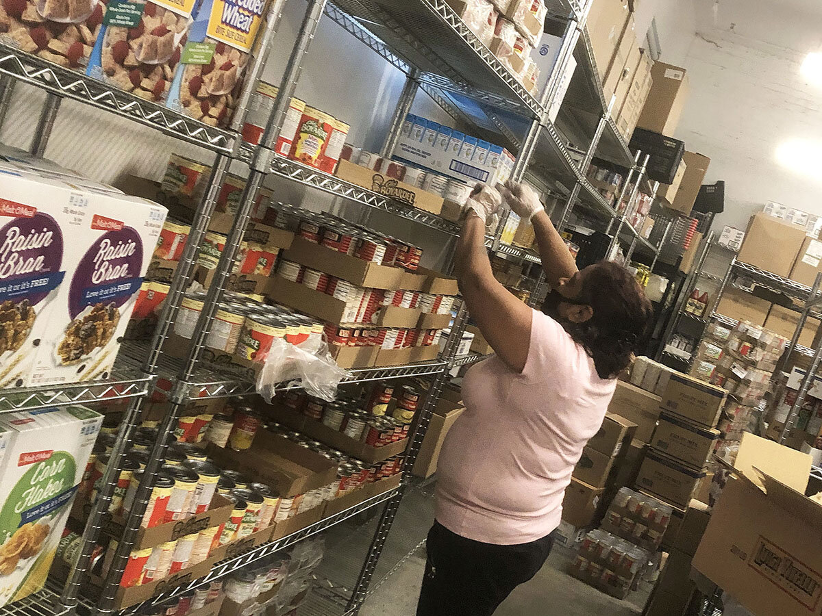 A staff member prepares items for pantry bags at Bread and Life’s food pantry / Photo Courtesy of St. John’s Bread and Life