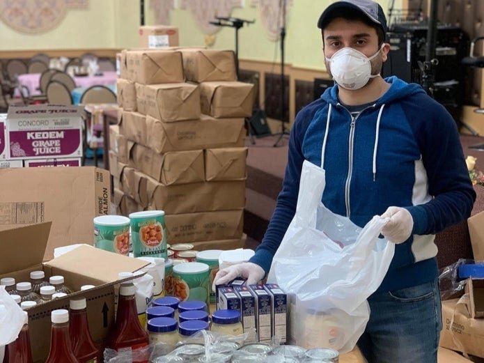 David Aronov, Queens Jewish Community Council board member, puts together Passover care packages. (Courtesy of David Aronov/Queens Jewish Community Council)