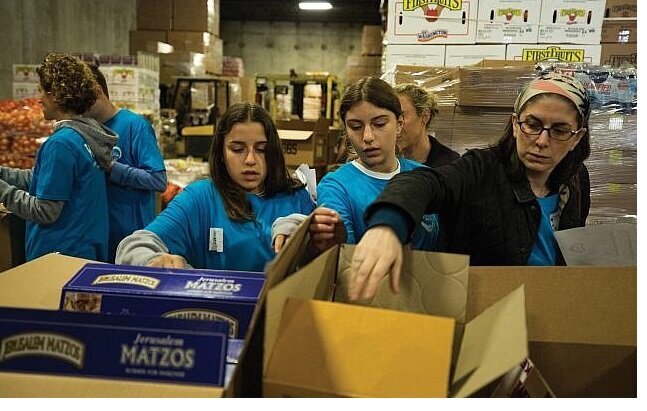 Met Council volunteers pack the tons of kosher-for-Passover goods distributed in the New York area in the weeks before the holiday. Photos courtesy of Met Council