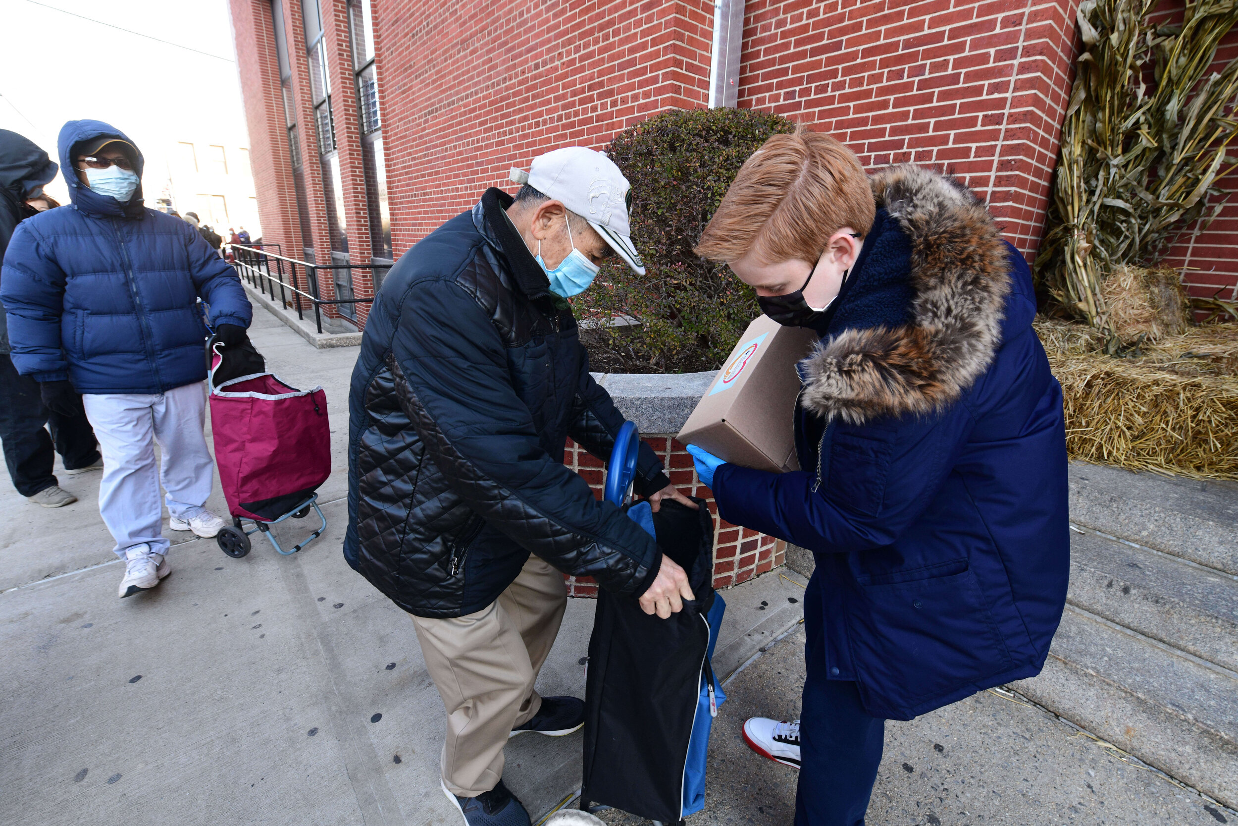 Lawrence Morton, 13, an eighth grader at the St. Peter’s Catholic Academy , loads wagon of person on line. (Photo by Todd Maisel)