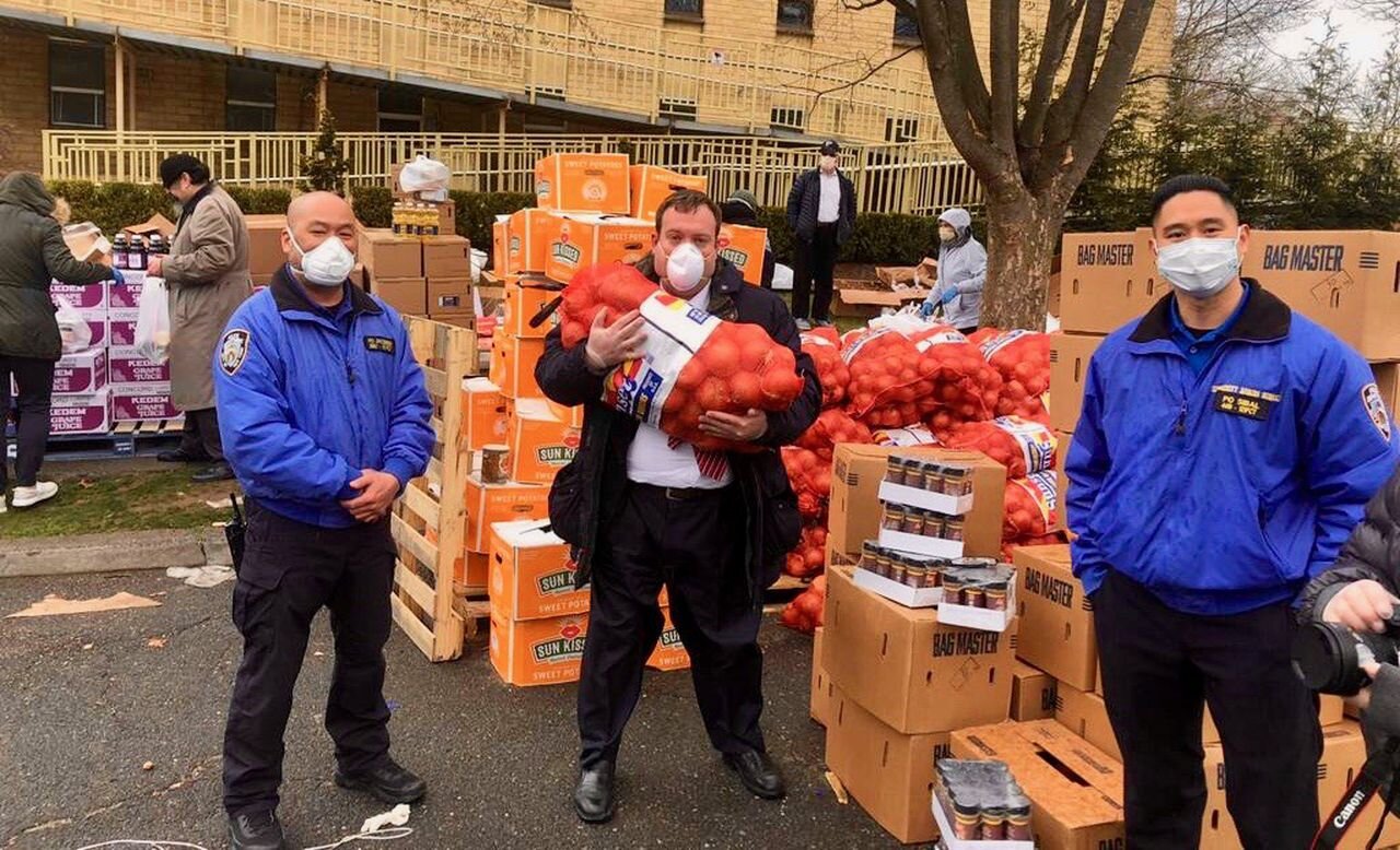 From the left, Police Officer Michael Jacobsen, Community Affairs, of the 121st Precinct; Mendy Mirocznik, President, COJO, and Officer John Sibal after packing Passover food packages at the 45th Annual Pre-Passover Food Distribution. (Courtesy/Mend…