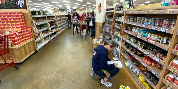 A worker takes stock as consumers empty shelves of food at a Trader Joe’s grocery store, gathering supplies as coronavirus fears spread in Encinitas, California, March 12, 2020. Photo: Reuters / Mike Blake.