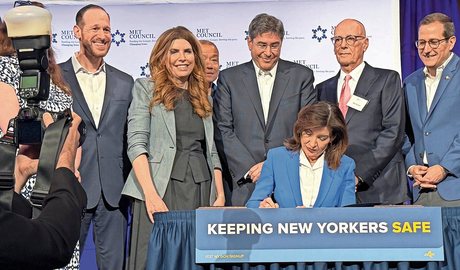 SIGNING IT: After speaking at Sunday’s Met Council Legislative Breakfast, Gov. Kathy Hochul signs “Keeping New Yorkers Safe” legislation, mandating buffer zone to protect houses of worship with 50-foot security perimeters in which protests are not allowed. Happily watching, from left: Met Council CEO and Executive Director David Greenfield, City Council Speaker Julie Menin, and UJA-Federation of New York CEO Eric Goldstein.